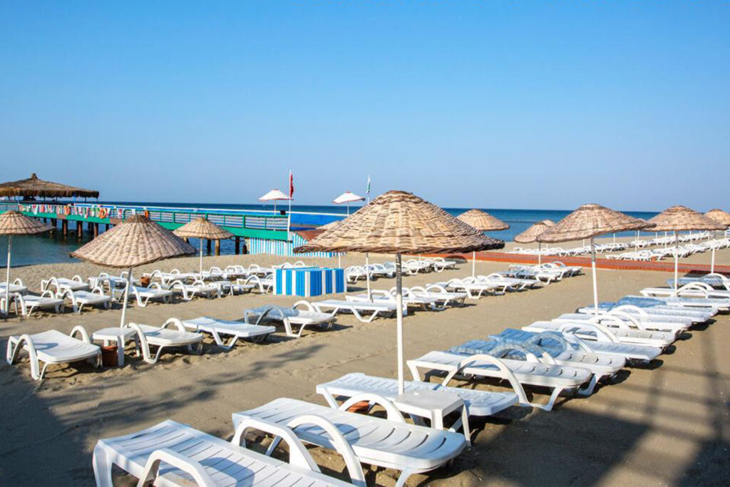 Colorful beach umbrellas and comfortable sunbeds near the pool at Marine Beach with a scenic view of the coast