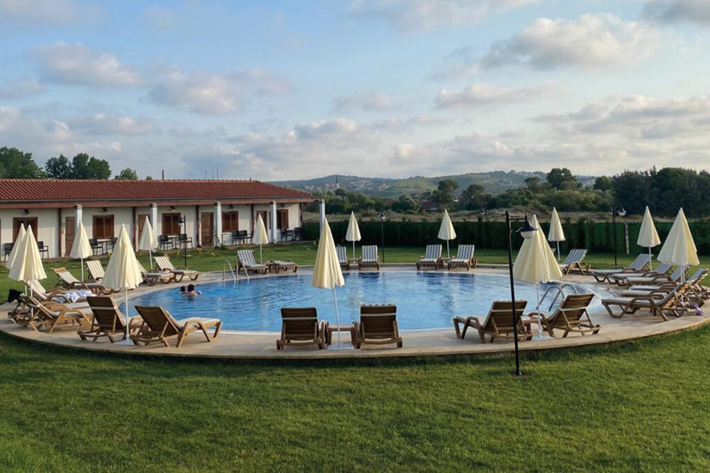 Relaxing pool area with an infinity edge, merging seamlessly with the blue waters of Sile Beach